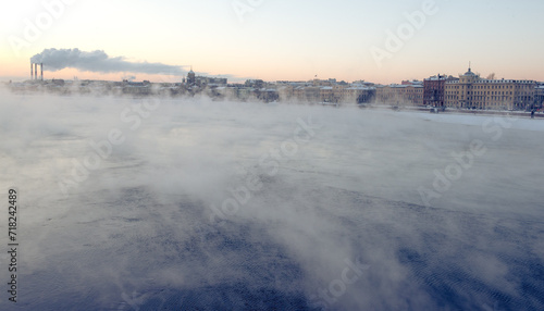 Evening mist above river and industrial pipes with smoke, St.Petersburg