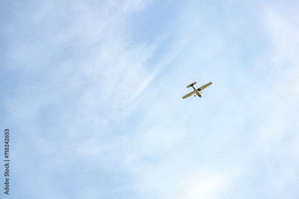 Single engine ultralight plane flying in the blue sky with white clouds. Small private plane flying in light white clouds, bottom view. Light aircraft in the sky with clouds, minimalistic style photo Single engine ultralight plane flying in the blue sky with white clouds. Small private plane flying in light white clouds, bottom view. Light aircraft in the sky with clouds, minimalistic style photo