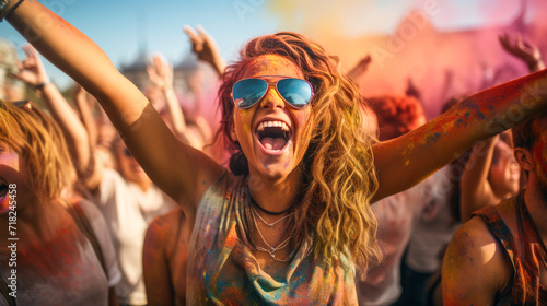 Fun with colours: A vibrant splash of colors and a young woman celebrating holi festival outdoors © Stewart Bruce