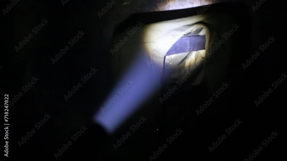 Lantern beam of light on military jacket on chair in dark on quest. Lantern beam of light on military jacket on chair in dark on quest.