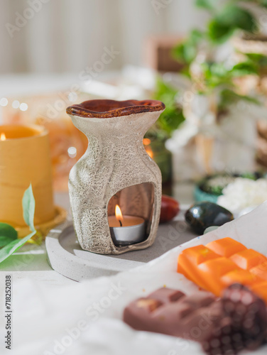 Aromatic wax for aroma lamp, melts, in the form of ice cream. Orange and chocolate color. Homemade mini wax melts in aromatherapy lamp diffuser at home interior. 
