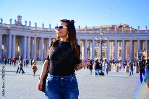 Rome,Italy, Vatican City, Rome, Saint Peter's Basilica in St. Peter's Square Young beautiful woman using a mobile phone taking a pictures.Concept of Italian gastronomy and travel