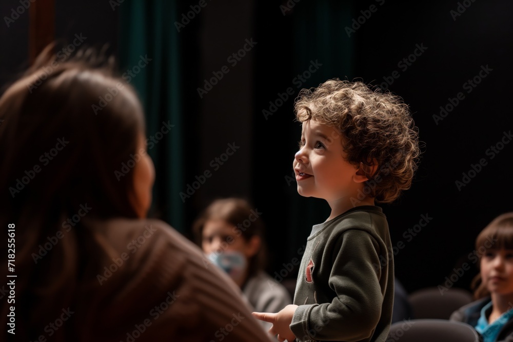 Young Child Confidently Addresses An Attentive Audience From The Stage. Сoncept Public Speaking Skills, Young Child Speaker, Confident Performance, Captivating Audience, Stage Presence Young Child Confidently Addresses An Attentive Audience From The Stage. Сoncept Public Speaking Skills, Young Child Speaker, Confident Performance, Captivating Audience, Stage Presence