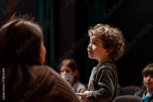 Young Child Confidently Addresses An Attentive Audience From The Stage. Сoncept Public Speaking Skills, Young Child Speaker, Confident Performance, Captivating Audience, Stage Presence © Anastasiia