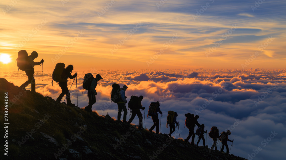 Hikers at Sunrise Above the Clouds