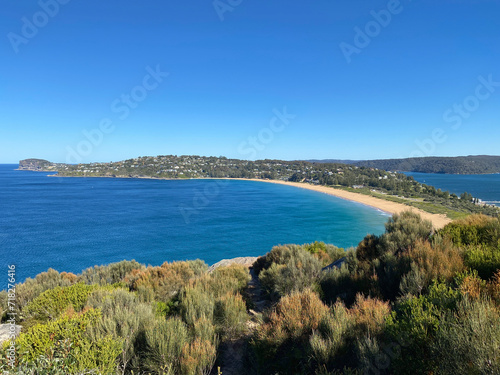 Narrow peninsular is surrounded by water on two sides. Panorama of the ocean. View of the mountain and the island's coastline. Palm beach, Australia, NSW. Beach that divides the ocean.