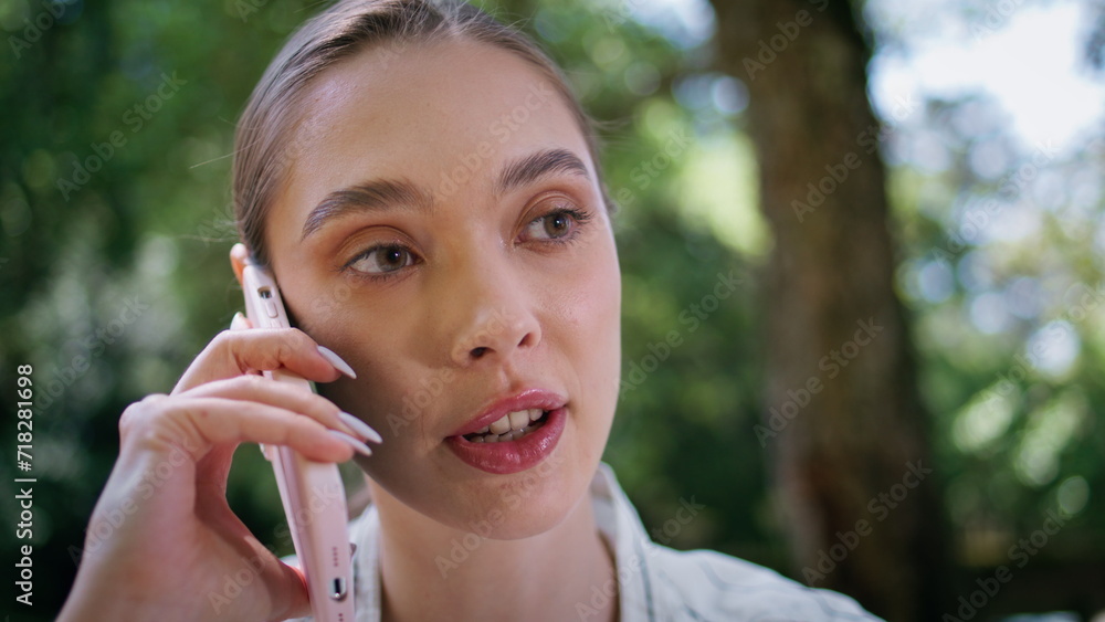 Closeup beautiful woman calling by mobile phone on nature. Serious lady speaking Closeup beautiful woman calling by mobile phone on nature. Serious lady speaking