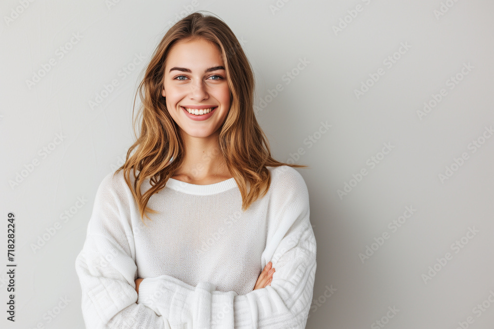 Fototapeta premium smiling woman in white sweater with arms folded