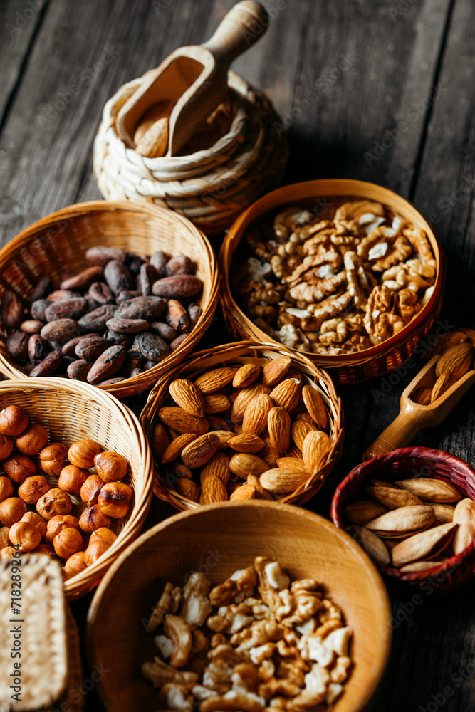 Handmade wicker baskets and wood plates with almonds, hazelnut, walnut. Vintage food background with different nuts and baskets. Handmade wicker baskets and wood plates with almonds, hazelnut, walnut. Vintage food background with different nuts and baskets.