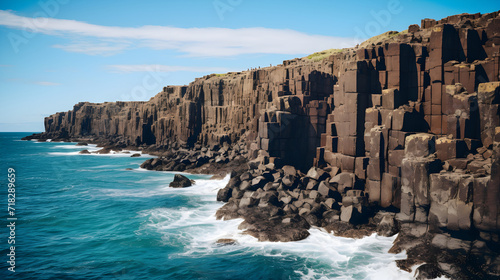 Eternal Stand: An imposing depiction of eroded cliffs set against the vibrant hues of the ocean and sky photo