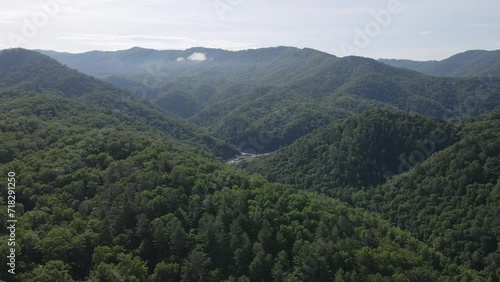 Green mountain covered trees opening up the interstate down below gracefully. 