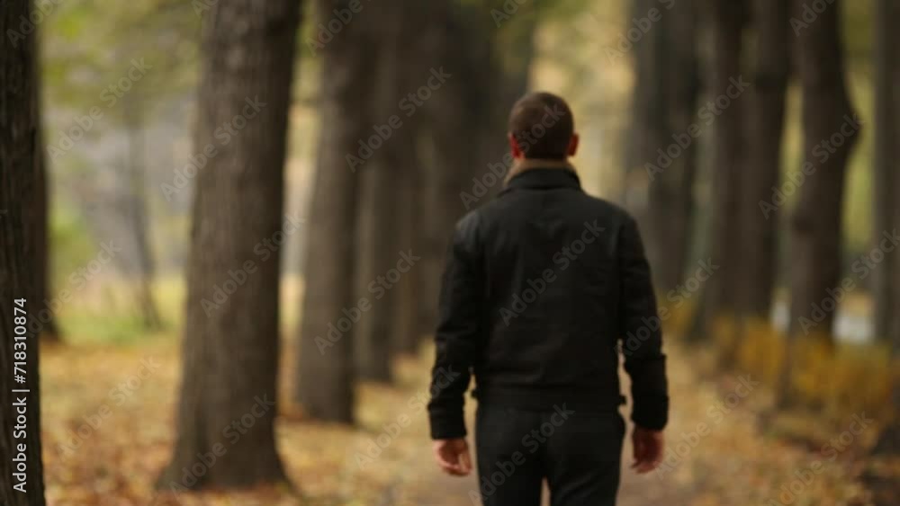 Man adjusts the collar of the jacket, goes and running down the alley Man adjusts the collar of the jacket, goes and running down the alley