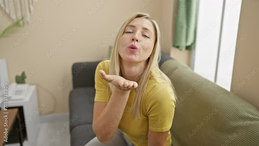 Adorable young blonde, wearing a t-shirt, playfully blowing a love-filled kiss at the camera, radiating sexy confidence right from her cozy home Adorable young blonde, wearing a t-shirt, playfully blowing a love-filled kiss at the camera, radiating sexy confidence right from her cozy home