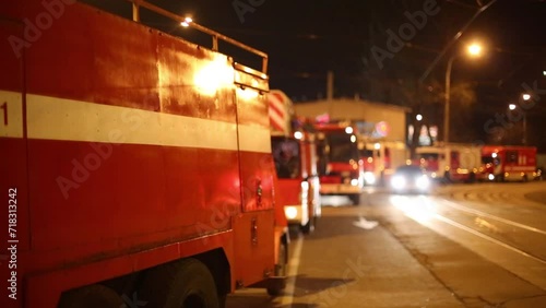 Fire trucks parked on the side of the road with tram tracks at night photo