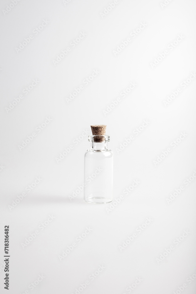 One empty mini glas bottle with closed brown cork lid standing up. The rustic and vintage jar is small and clean. It looks like an old medicin keeping. 