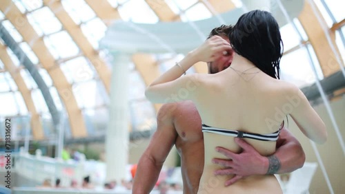Beautiful young man and woman embracing in the aquapark photo