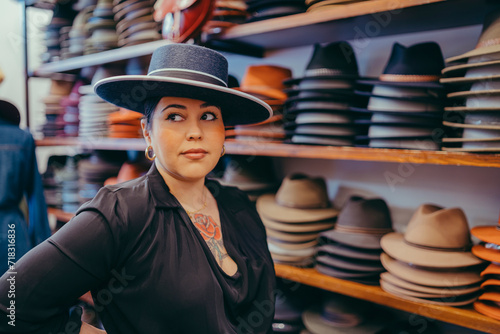 Mujer guapa con sombrero de ala ancha en tienda de sombreros photo