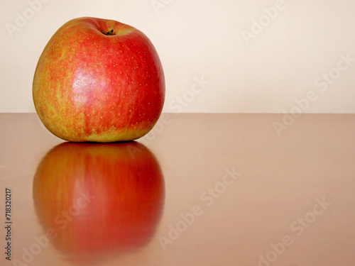 czerwone jabłko na stole, jabłko odbite w lakierowanym blacie stołu, fresh red apple on a wooden table 