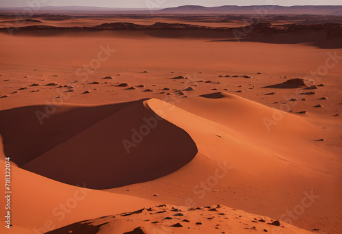 A Red Desert Landscape With Hills In The Background.