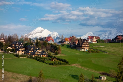 Landscape of High Tatras with luxury villas, hotels in Murzasichle village providing accommodation, snowy peaks