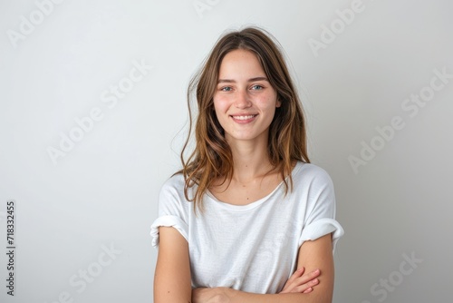 Happy woman standing with arms crossed against white background