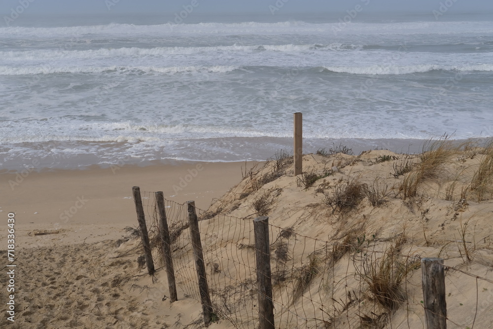 A small sand path to reach the beach and the Atlantic ocean. Cap Ferret, France - January 23, 2024: A small sand path to reach the beach and the Atlantic ocean. Cap Ferret, France - January 23, 2024: