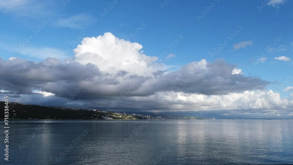 Slow motion fluffy clouds moving against the blue sky on a windy afternoon. Magnificent nature landscape with Rijeka in the background. White tropical clouds above the sea with beautiful reflections. Slow motion fluffy clouds moving against the blue sky on a windy afternoon. Magnificent nature landscape with Rijeka in the background. White tropical clouds above the sea with beautiful reflections.