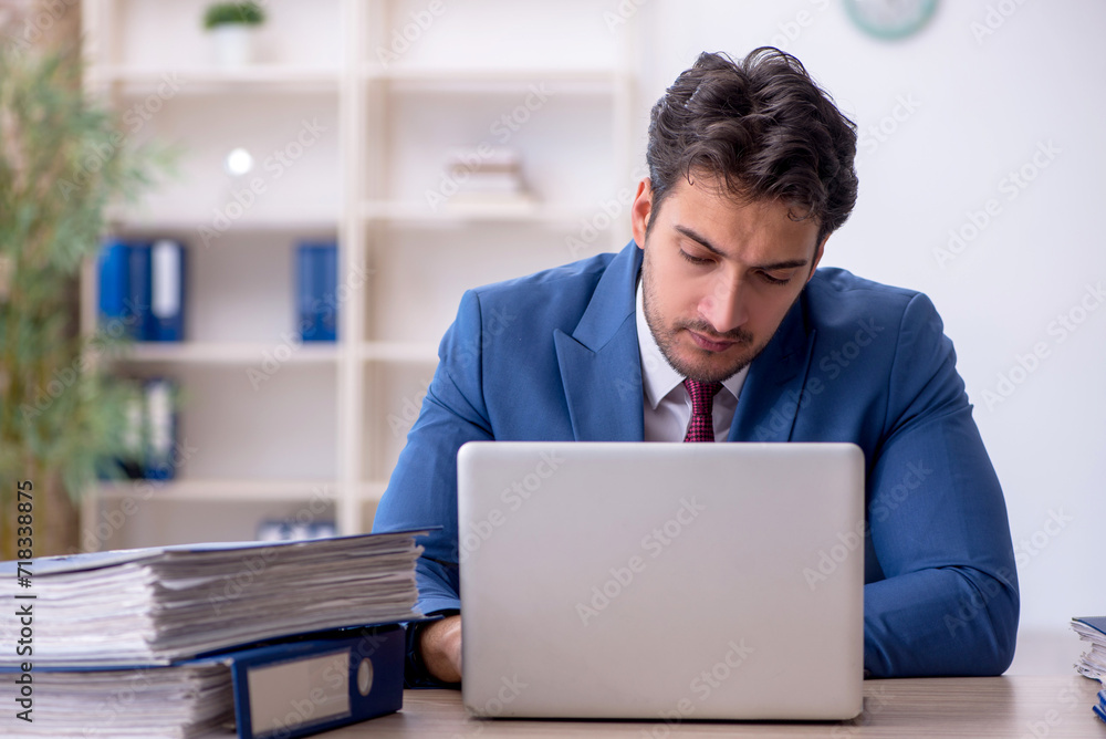 Young male employee working in the office Young male employee working in the office