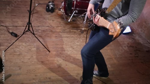 Man yanks on electric guitar during survey in studio photo