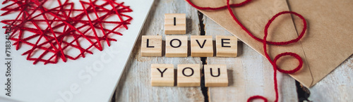 Beautiful wooden letterI love you on wooden background. Lovely cute handmade greeting card with red heart embroidering for Mothers or Saint Valentine's day, wedding or anniversary banner