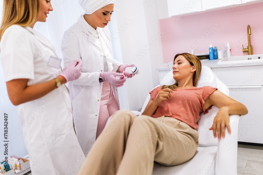 Obraz premium The dermatologist examines the moles or acne of the patient with a dermatoscope. Prevention of melanoma