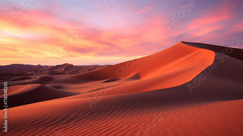 A striking photograph of a desert landscape at dusk  featuring towering sand dunes bathed in the warm hues of the setting sun  against a vibrant orange and pink sky