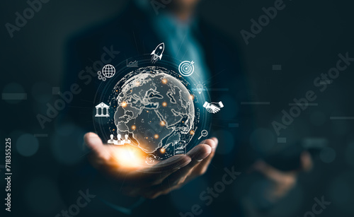 Businessman holding globe virtual on hand with business icons. Global internet connection application technology and digital marketing. Market link tech, internet of things, Big data tools, financial,