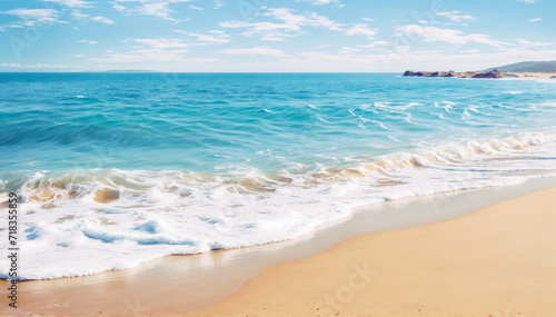sandy beach with a blue ocean in the background white foam on water