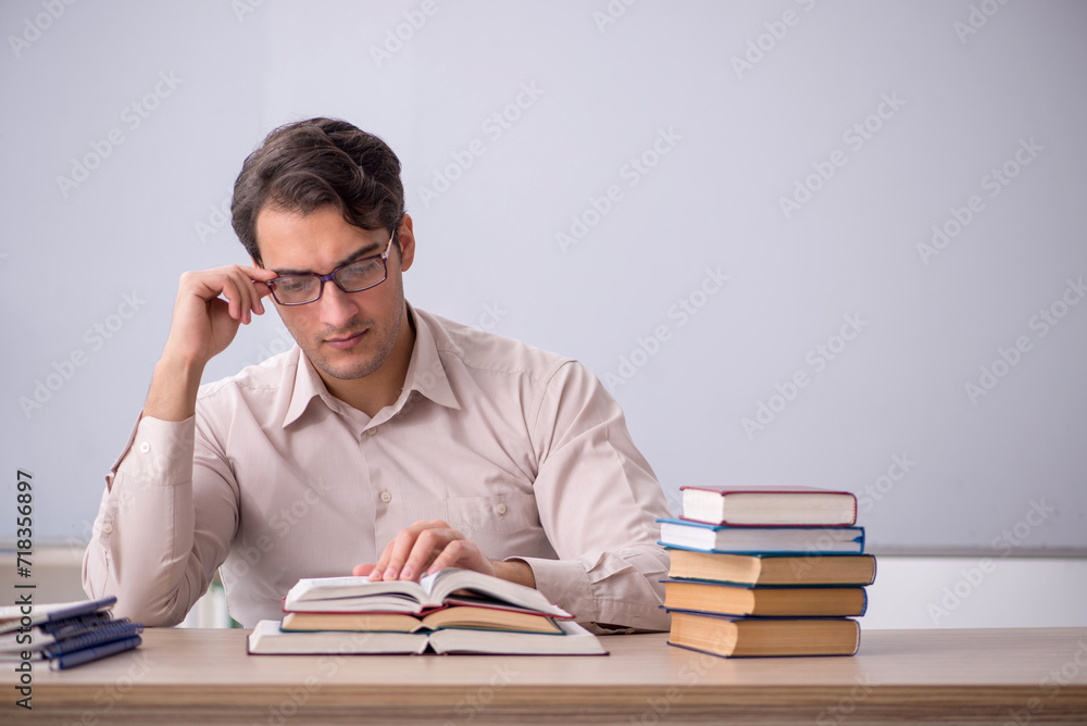 Young male teacher student sitting in the classroom Young male teacher student sitting in the classroom
