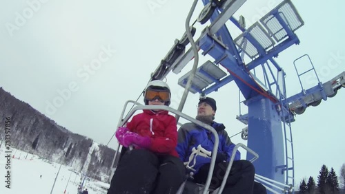 Man with girl makes selfie on cableway in ski resort, under view photo