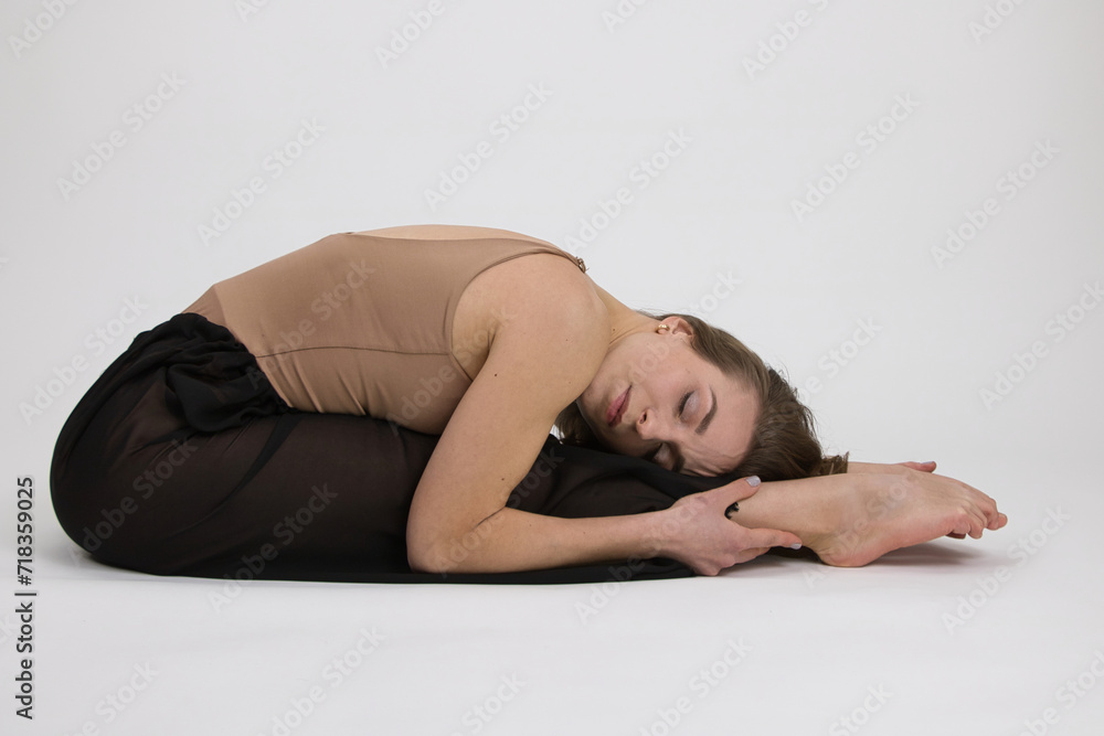 A girl dancer demonstrates dance movements in the style of modern dance on a white background. A girl dancer demonstrates dance movements in the style of modern dance on a white background.