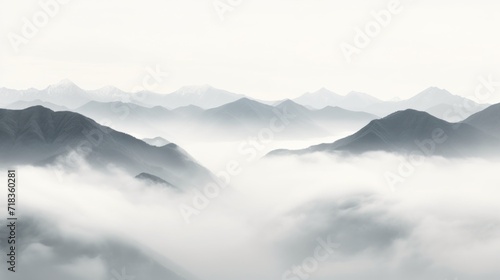  a black and white photo of a mountain range with low lying clouds in the foreground and low lying mountains in the background.