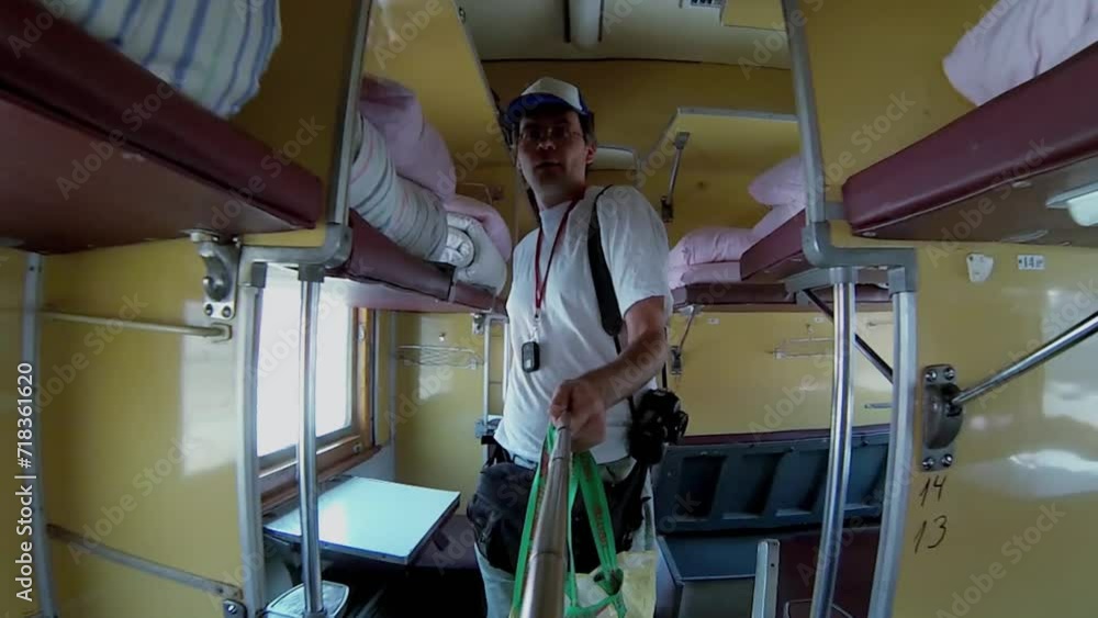 Passenger with bags walks through sleeping car before trip. Passenger with bags walks through sleeping car before trip.