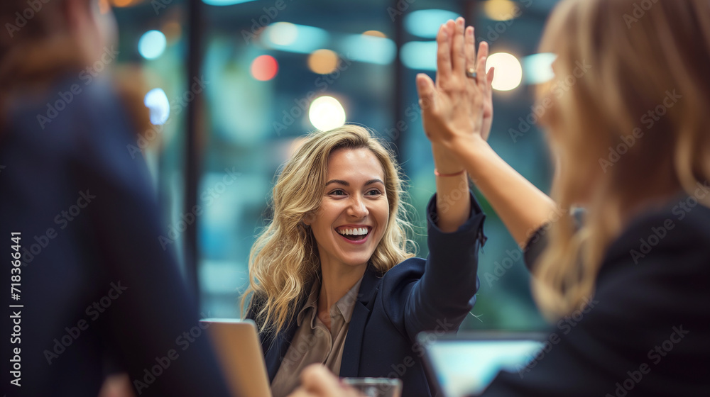 Obraz premium Businesswoman giving a high five to the colleague in meeting room celebrating success. Happy confident business people high-five. Job well done. 