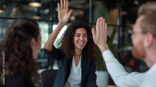 Businesswoman giving a high five to the colleague in meeting room celebrating success. Happy confident business people high-five. Job well done. 