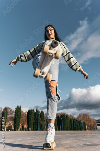 Young brunette skater stepping on camera. Low-angle image of a young caucasian woman with dark hair and quad roller skates stepping on the camera lens.