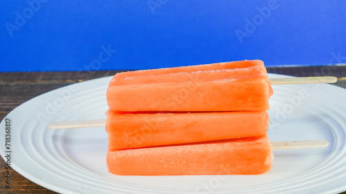 Cold summer fruit popsicles on plate with copy space