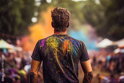 Rear view of a man in a black T-shirt stained with paint. Festival of colors. Generated by artificial intelligence