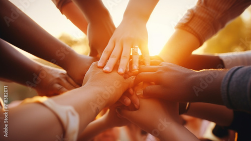 Emotion of connection, close-up image of diverse hands reaching for each other against a sunrise, symbolising unity in the face of global warming, photo