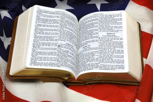 American flag draped under a New Testament bible photo