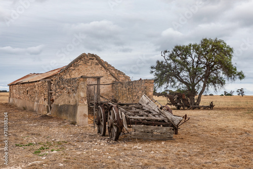 Remains of an old stone stable with an old wooden cart and plough in a field - Yorke Peninsula, South Australia