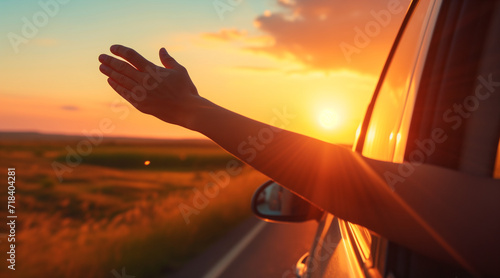 Road trip concept - hand held out of an open window, sunset in the foreground. vacations. travalling concept