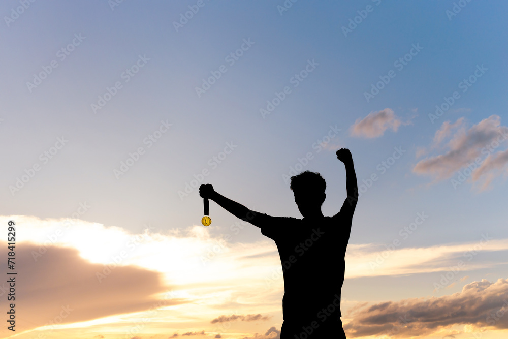 Silhouette of an athlete celebrating the gold medal against a sunset sky adorned with golden clouds in the background. Ideal for conveying the spirit of success in sporting events. Silhouette of an athlete celebrating the gold medal against a sunset sky adorned with golden clouds in the background. Ideal for conveying the spirit of success in sporting events.