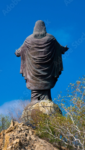 View of Cristo Rei statue of Jesus Christ with open palms overlooking blue sky in Dili, Timor-Leste photo